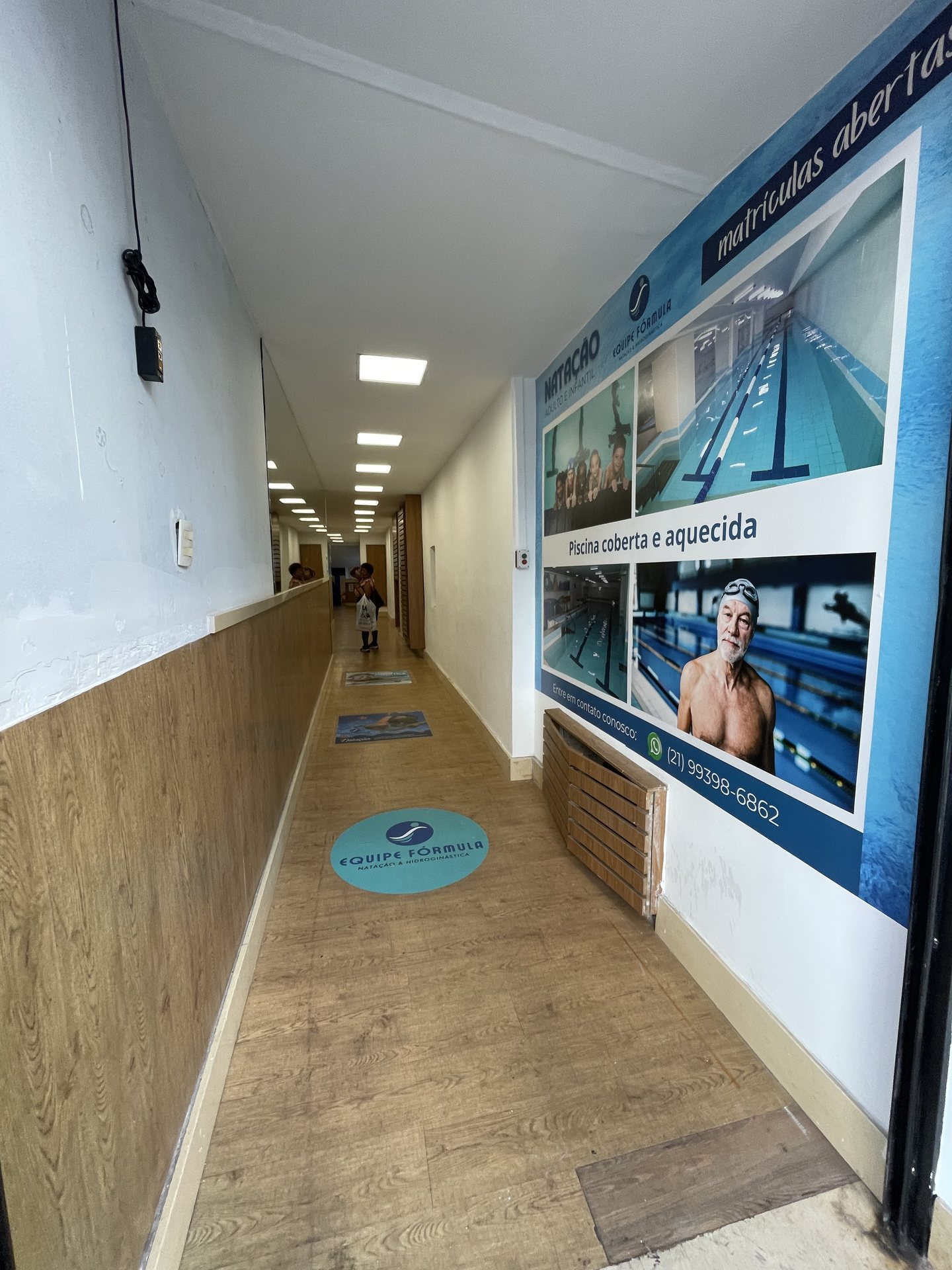 Corredor de chegada da academia com o logo na parede