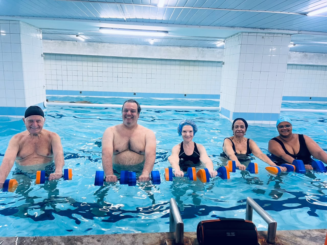 Turma de hidroginástica com halteres na piscina aquecida da Academia Equipe Fórmula