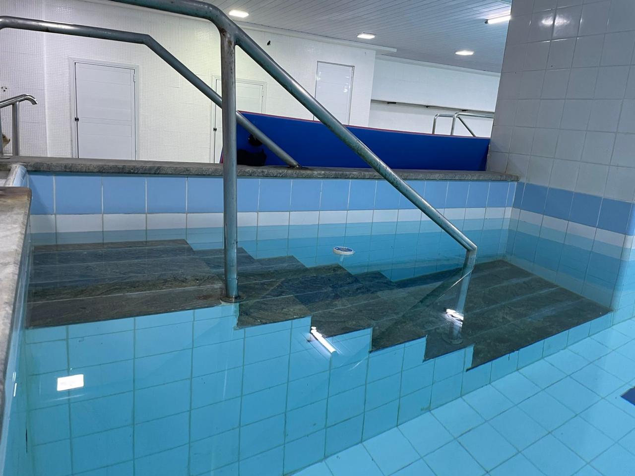 Escadas de acesso à piscina com corrimão de apoio